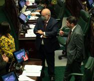 Los portavoces de las delegaciones del PNP y PPD, Carlos "Johnny" Méndez (al centro) y Ángel Matos (derecha), dialogan con otros legisladores durante la sesión legislativa.