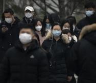 Transeúntes con mascarilla caminan por una calle de un distrito empresaria en el centro de Beijing, China, el 12 de enero de 2023.
