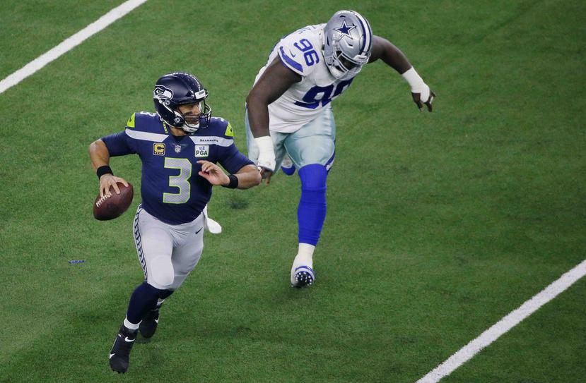 El quarterback Russell Wilson (3), de los Seahawks de Seattle, sale de la bolsa de protección en el choque ante los Cowboys de Dallas, el sábado 5 de enero de 2019, en Arlington, Texas. (AP)