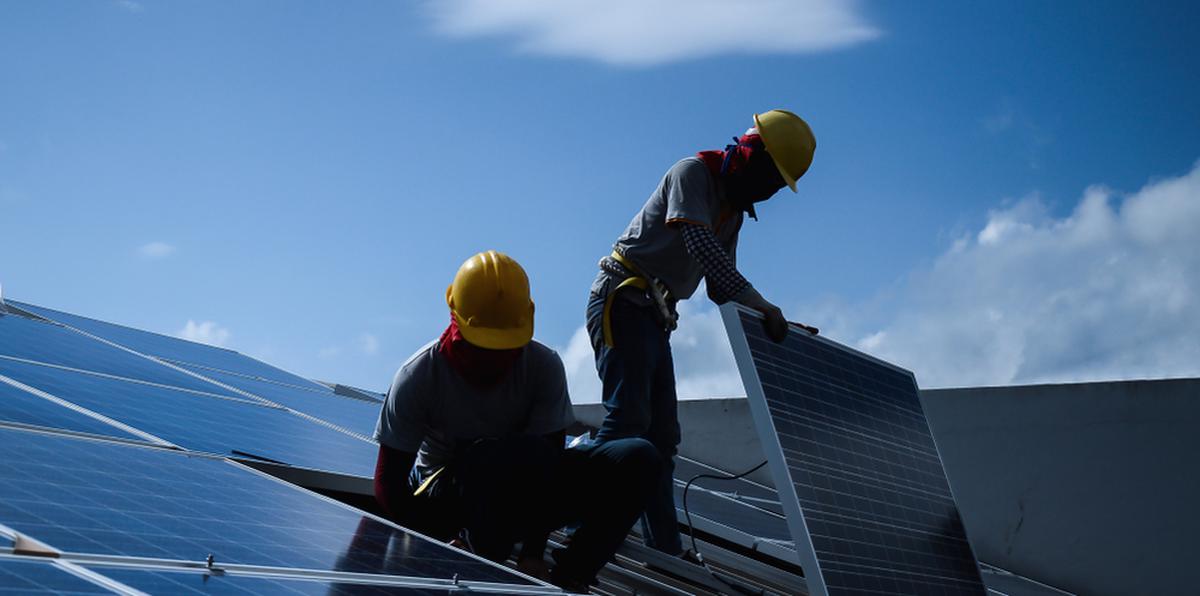 Imagen que ilustra a dos trabajadores instalando placas solares.
