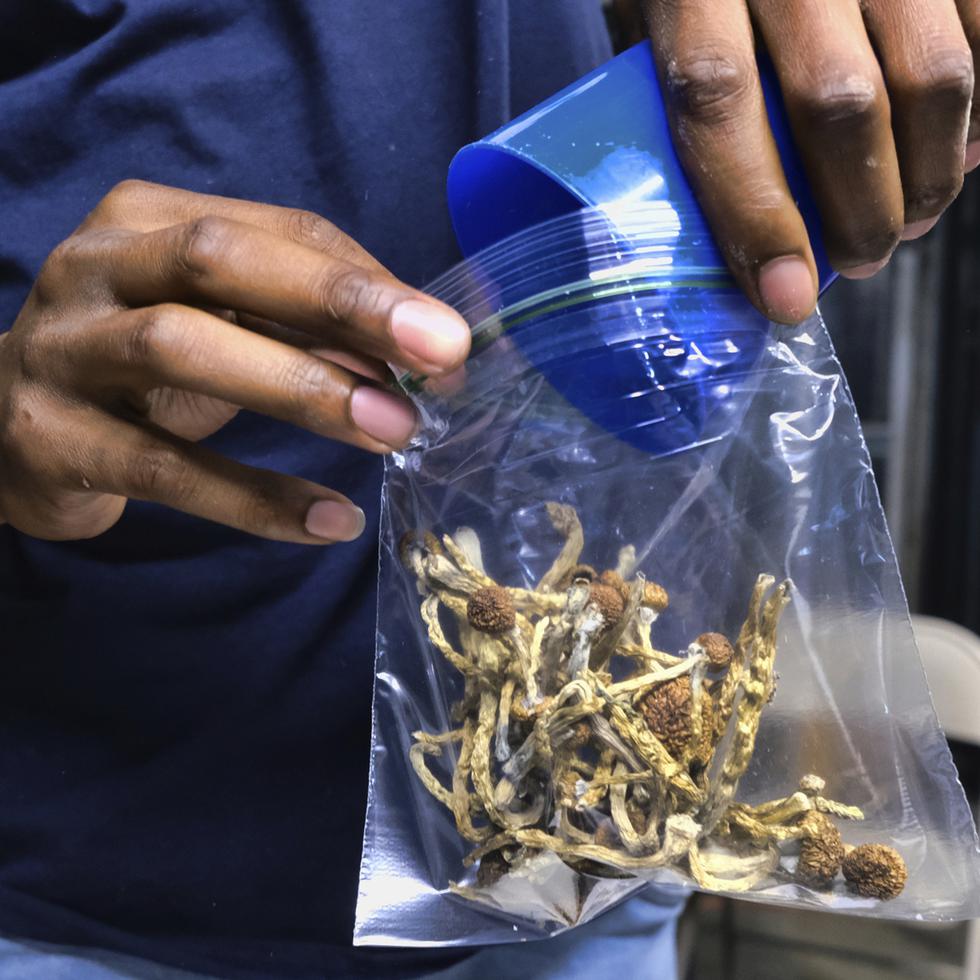 Un vendedor guarda en una bolsa unos hongos psicodélicos en una tienda de cannabis, el 24 de mayo de 2019, en Los Ángeles.