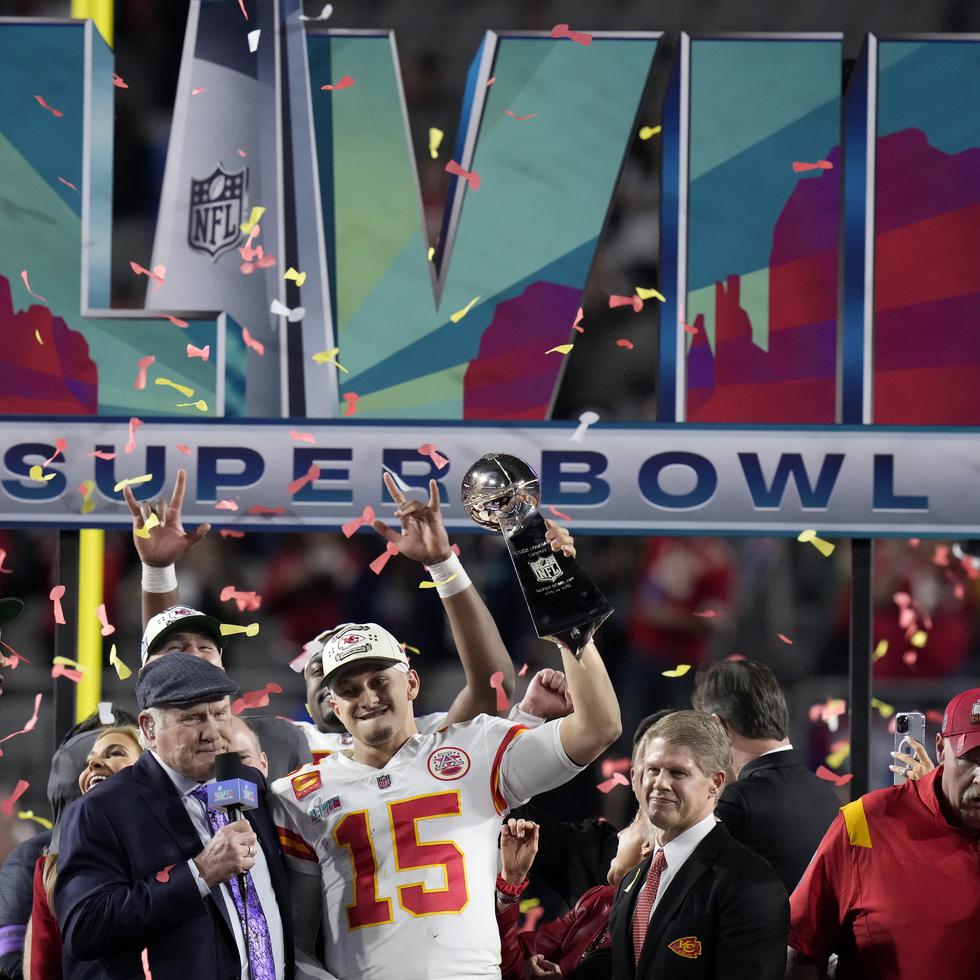 El quarterback de los Chiefs de Kansas City Patrick Mahomes sostiene el trofeo Vince Lombardi mientras habla con Terry Bradshaw tras ganar el Super Bowl 57.