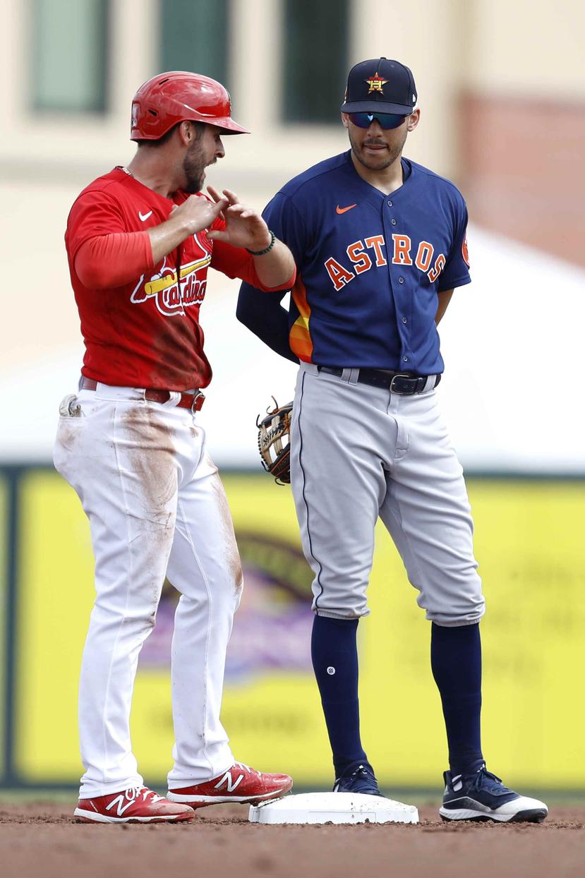 Paul DeJong, de los Cardinals, y el puertorriqueño Carlos Correa, de los Astros, durante un partido de pretemporada a principios de marzo 2020. (AP)