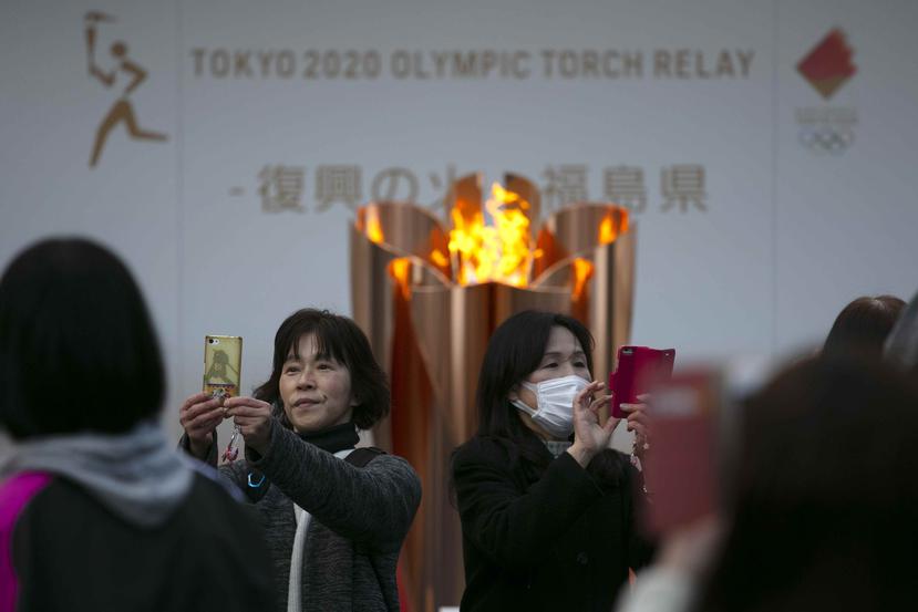 Personas se toman selfies con la llama olímpica en Fukushima. (AP)