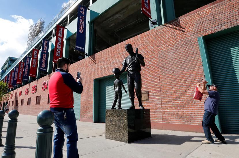 Dos fanáticos de los Medias Rojas se detienen en los alrededores del Fenway Park para retratar la estatua del legendario Ted Williams, cuando la novena local abrirá mañana la Serie de Campeonato de la Liga Americana ante Houston. (AP / Elise Amendola)