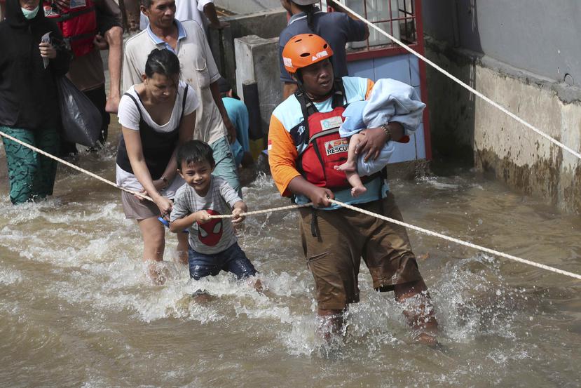 Un rescatador evacua a un bebé en un barrio inundado en Tanggerang, en las afueras de Yakarta, Indonesia. (AP)