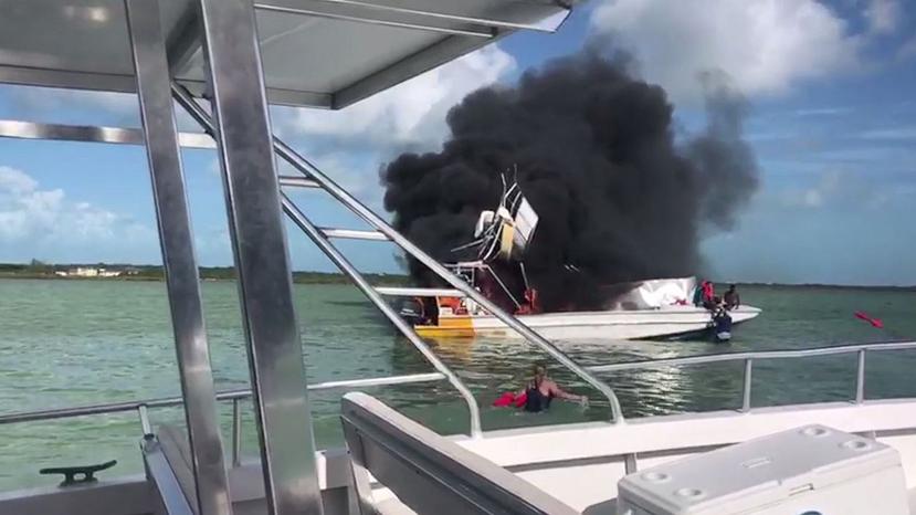 Imágenes de televisoras locales muestran la embarcación en medio de humo negro y a personas de botes vecinos prestando su ayuda a algunos heridos que se arrojaron al agua. (Captura)

