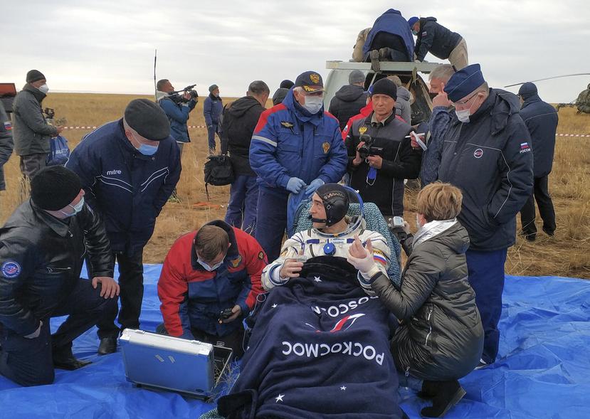 En esta foto, el astronauta de Roscosmos Anatoly Ivanishin se sienta para ser asistido luego del aterrizaje cerca de la ciudad Dzhezkazgan, Kazakhstan en Rusia.