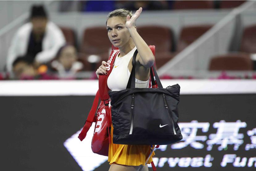 a rumana Simona Halep se despide de los aficionados tras abandonar su duelo con la tunecina Ons Jabeur en la primera ronda del Abierto de China debido a una lesión de espalda. (AP)