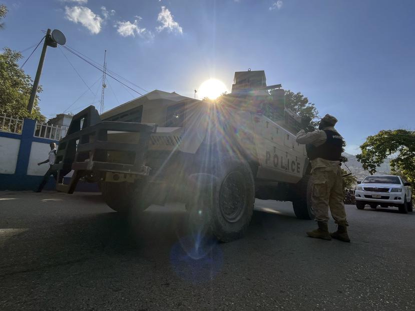 Un policía nacional habla con sus colegas junto a un vehículo policial blindado en Puerto Príncipe, Haití, el sábado 21 de enero de 2023.