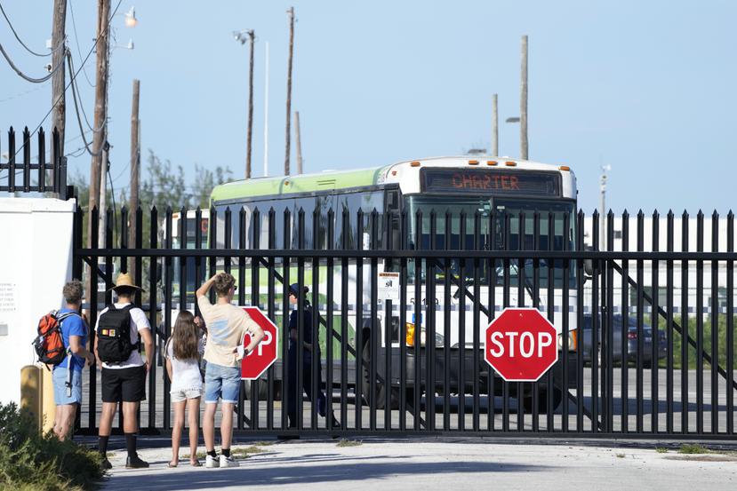 Un grupo de personas observa la salida de autobuses con migrantes cubanos de las instalaciones de la Guardia Costera de Estados Unidos, el jueves 5 de enero de 2023, en Key West, Florida.