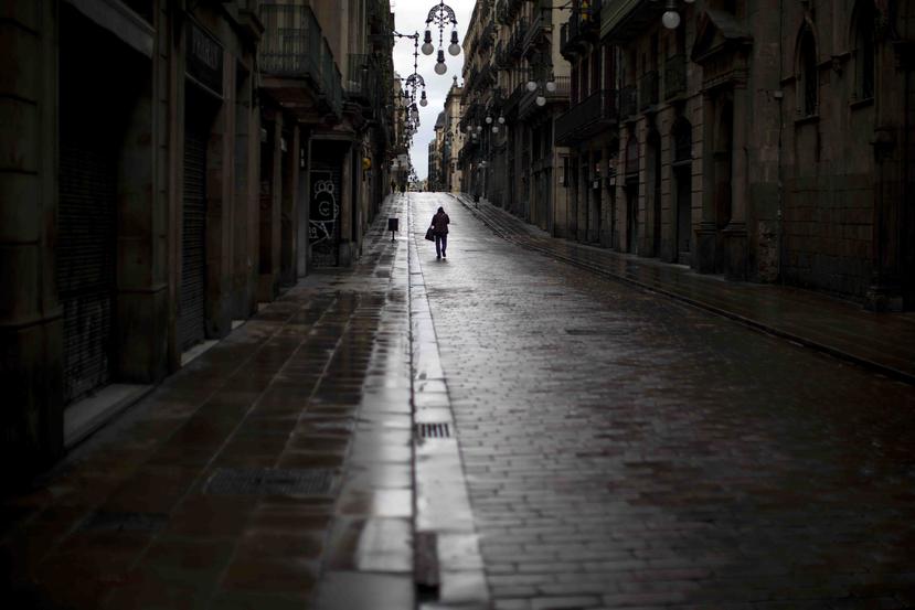 Un hombre camina por una calle desierta en Barcelona, España. (AP)