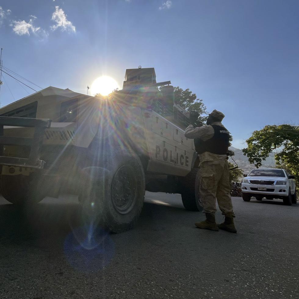 Un policía nacional habla con sus colegas junto a un vehículo policial blindado en Puerto Príncipe, Haití, el sábado 21 de enero de 2023.
