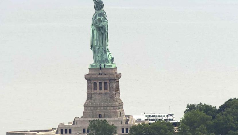 Personas escalando el pedestal de la Estatua de la Libertad. (AP)