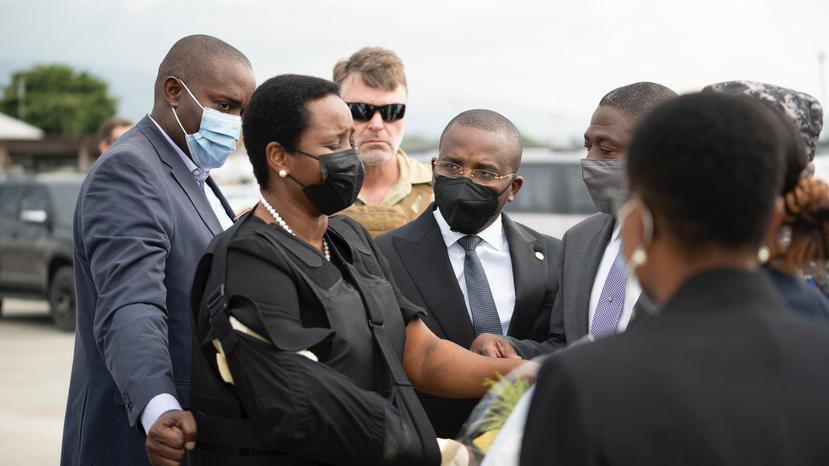 Esta foto, facilitada por la Secretaría de Estado para las Comunicaciones de Haití, muestra a la primera dama Martine Moïse con un chaleco antibalas y un cabestrillo en el brazo derecho a su llegada al aeropuerto internacional Toussaint Louverture, el sábado 17 de julio de 2021, en Puerto Príncipe, Haití.