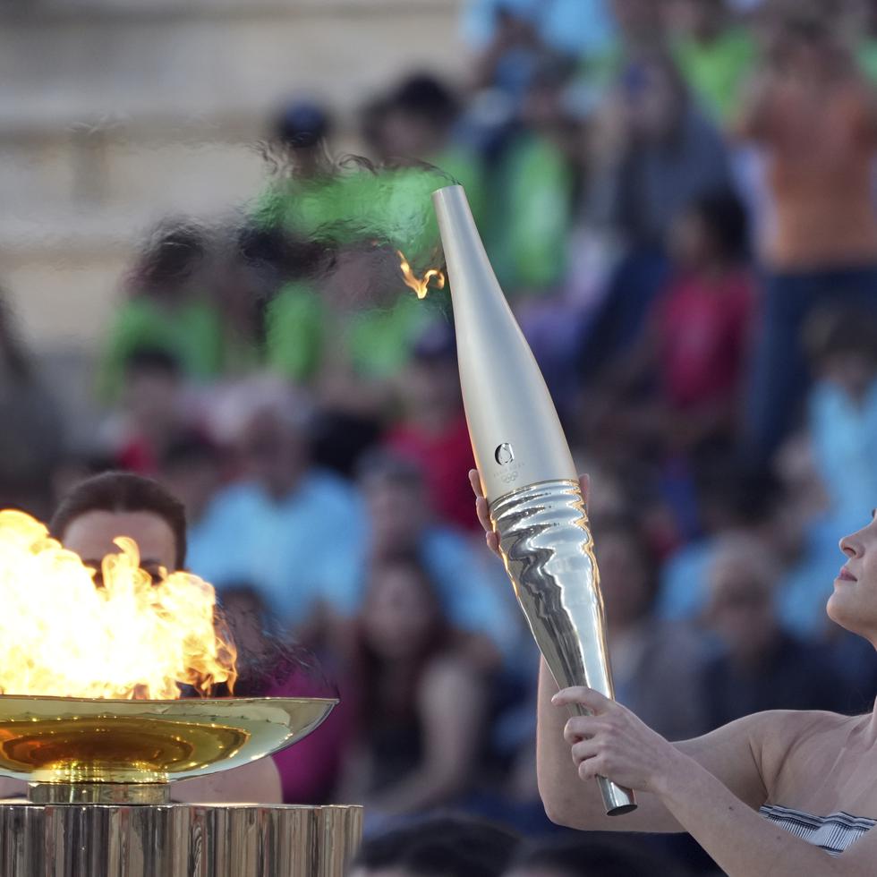 La actriz Mary Mina, como una sacerdotisa griega, sostiene una antorcha con la llama de los Juegos Olímpicos.