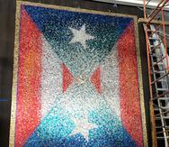 La obra El resplandor fue creada con latas de aluminio que forman dos banderas puertorriqueñas, una orientada de sur a norte y otra de norte a sur.