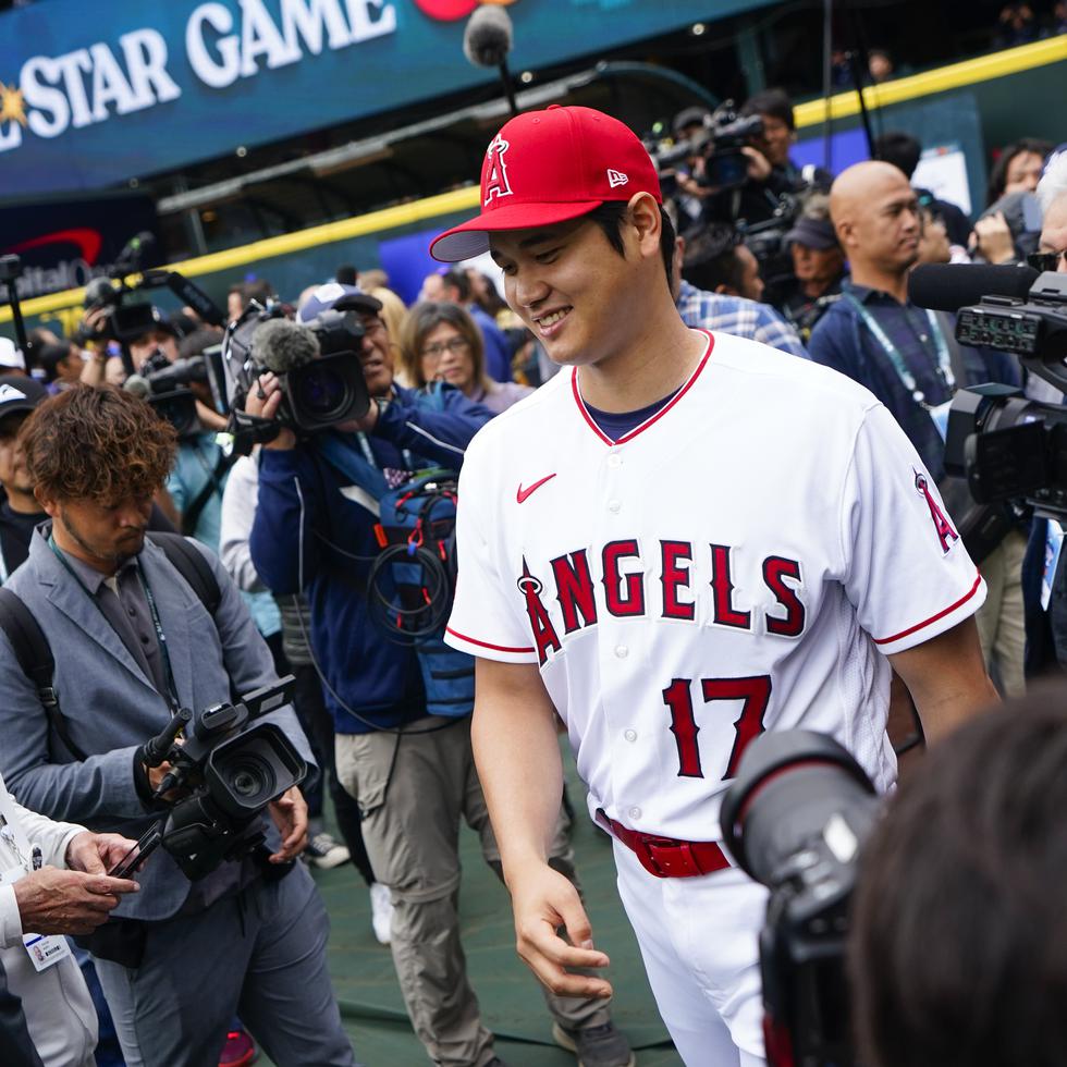 Shohei Ohtani jugador de Los Angels de Los Ángeles de la Liga Americana sonríe mientras camina hacia los jardines luego de atender a los medios en Seattle.