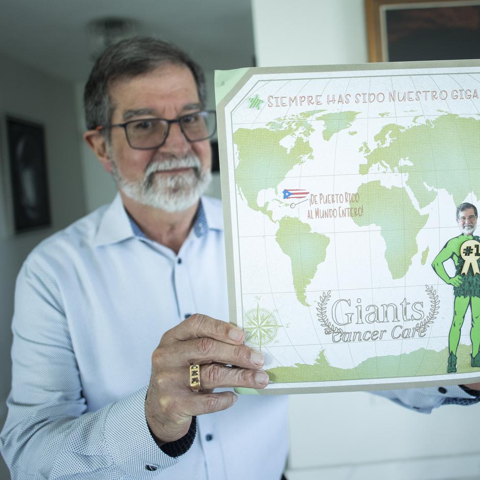 El doctor oncólogo Fernando Cabanillas muestra el afiche que le hicieron sus hijas cuando ganó el premio Giants of Cancer.