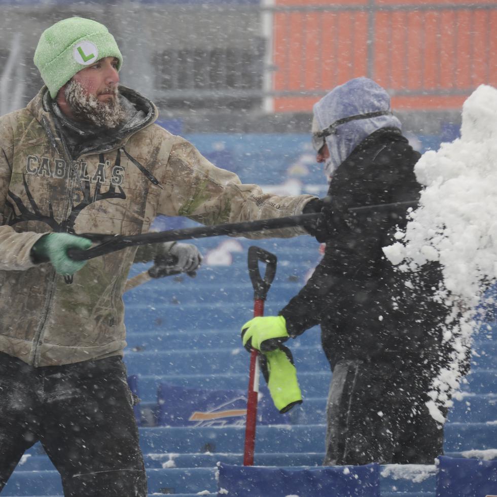 Trabajadores remueven nieve en el estadio de los Bills.