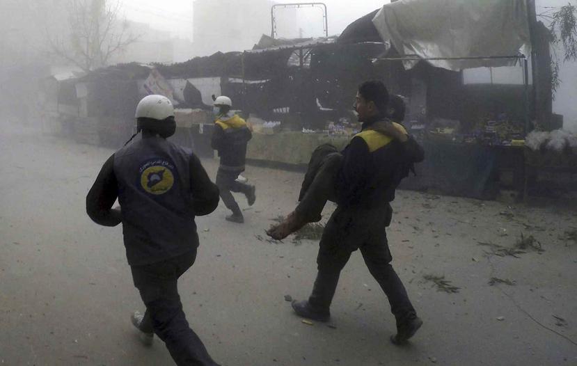 Personal del grupo Defensa Civil Siria, conocido como Cascos Blancos, trasladan a un herido después de los ataques aéreos contra un suburbio en poder de los rebeldes cerca de Damasco, en Siria. (AP)