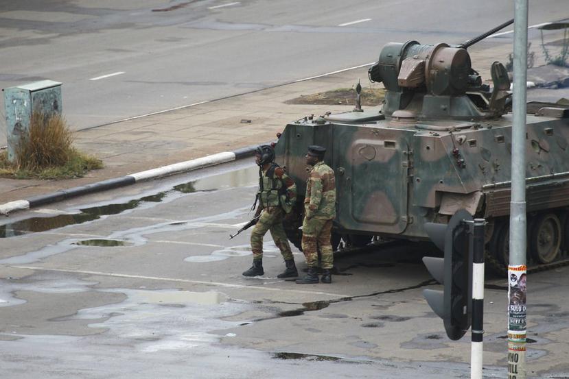 Un tanque militar y dos soldados armados en una calle próxima a la oficina del presidente Robert Mugabe en Harare, Zimbabue (AP).