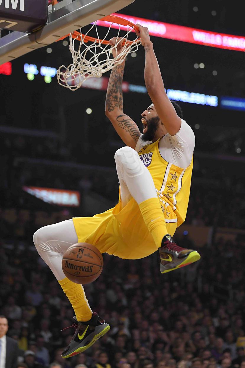 El jugador de los Lakers de Los Ángeles Anthony Davis se cuelga del aro de la canasta tras una clavada en la primera mitad del juego que enfrentó a su equipo con los Pelicans de Nueva Orleans. (AP)
