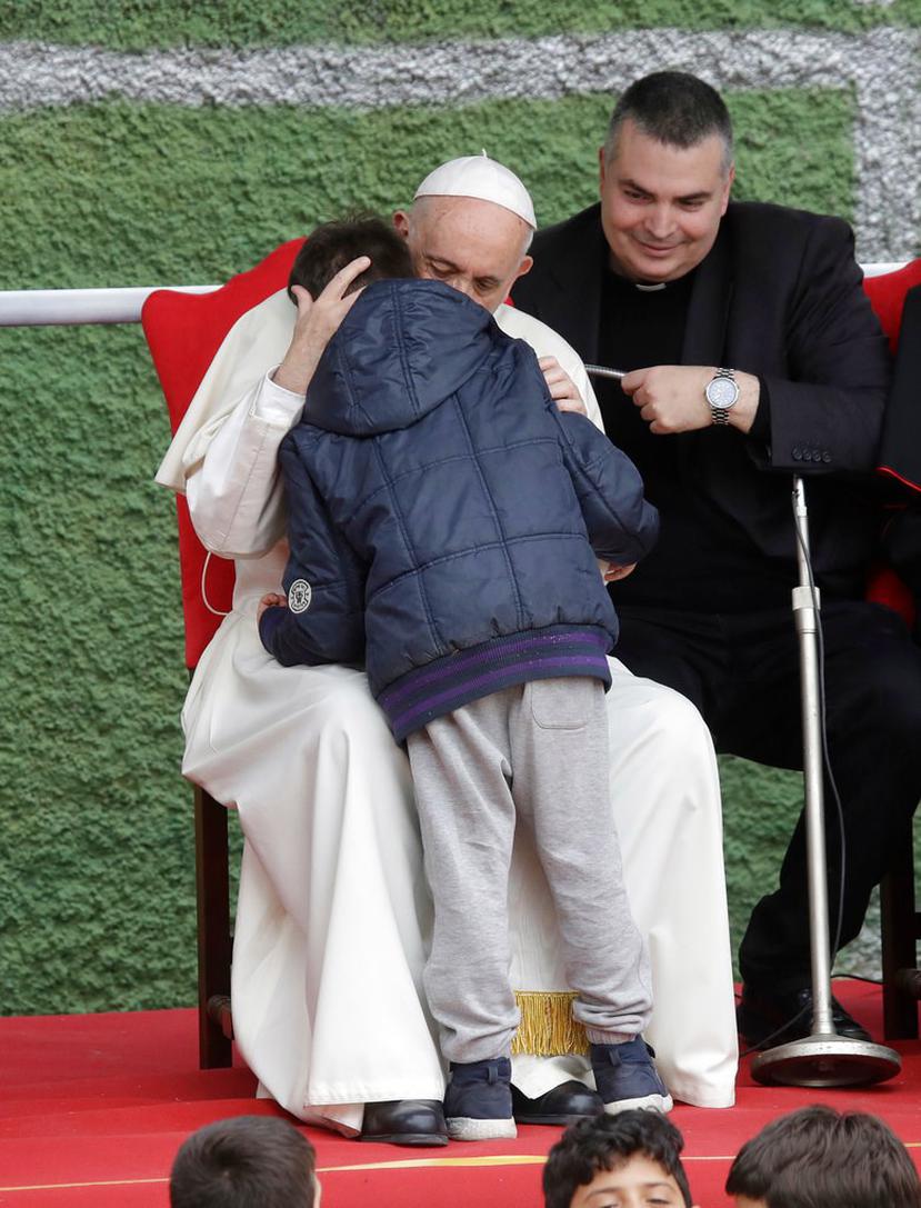 El Papa Francisco abraza al pequeño Emanuele durante su visita a la iglesia parroquial de San Paolo della Croce, en el barrio de Corviale, Roma (AP  / Alessandra Tarantino).
