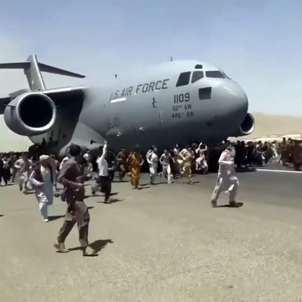 Cientos de personas corren junto a un avión C-17 de las fuerzas armadas de Estados Unidos en el aeropuerto de Kabul en Afganistán. (UGC vía AP)
