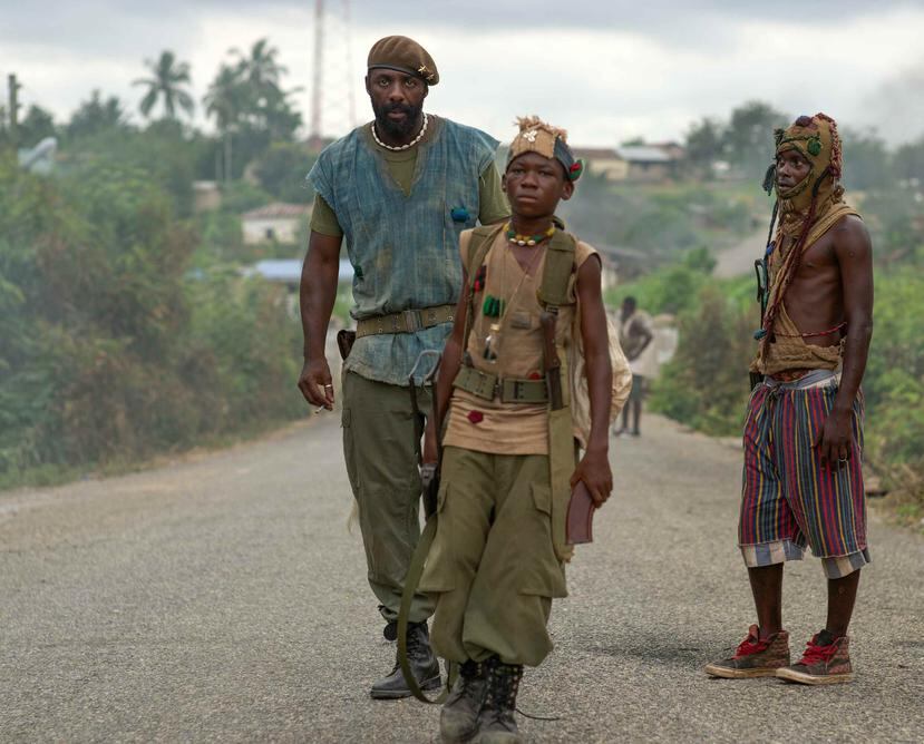 Idris Elba, a la izquierda, interpreta al Comandante, y Abraham Attah, al centro a Agu. (Netflix/AP)