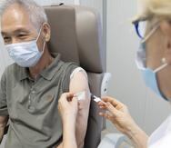 Un hombre recibe una dosis de la nueva vacuna Moderna Spikevax mRNA COVID-19 en el centro de vacunación de los Hospitales Universitarios de Ginebra, que abrió al público para recibir el cuarto refuerzo dosis contra la covid-19 en Ginebra este lunes. EFE/EPA/SALVATORE DI NOLFI
