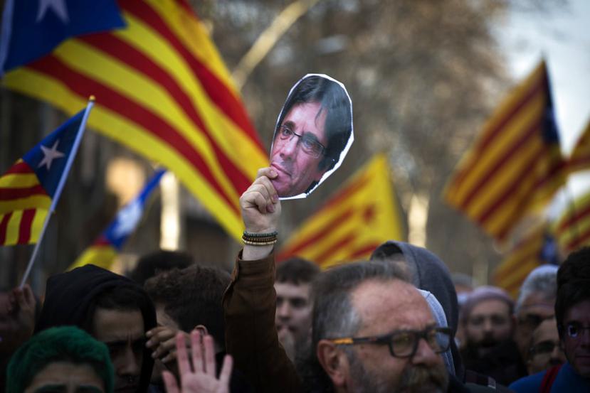 Un manifestante sostiene una imagen del expresidente catalán Carles Puigdemont durante una protesta afuera del Parlament de Cataluña, en Barcelona, España (AP / Emilio Morenatti).
