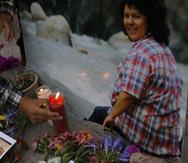 Un hombre coloca una vela encendida junto a una imagen de la activista ambiental y de derechos indígenas Berta Cáceres en una ceremonia espiritual, un día antes de un juicio contra uno de los presuntos autores intelectuales del asesinato de Cáceres, en Tegucigalpa, Honduras, el lunes 5 de abril de 2021.