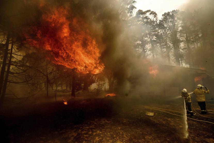 Bomberos combaten el incendio de Morton mientras consume una casa cerca de Bundanoon, Nueva Gales del Sur, Australia. (AP)