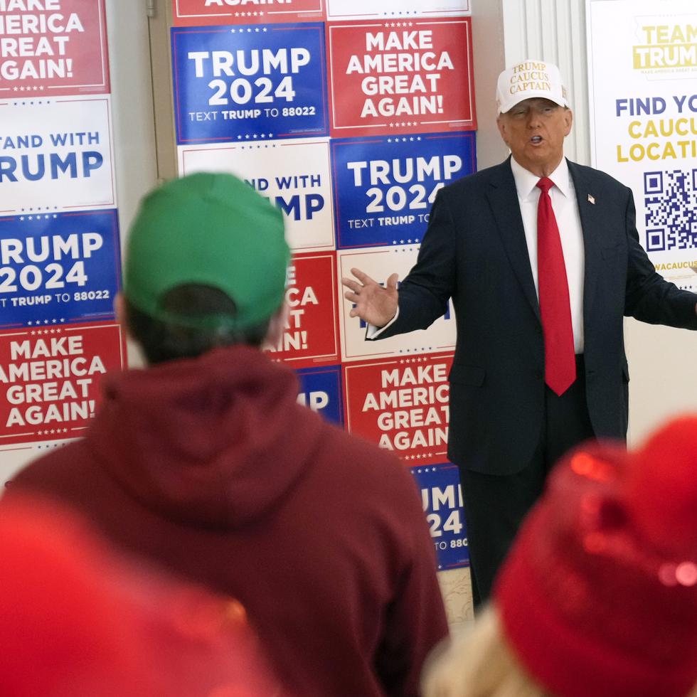 El expresidente y precandidato republicano presidencial Donald Trump habla con voluntarios en el Hotel Fort Des Moines en Iowa.