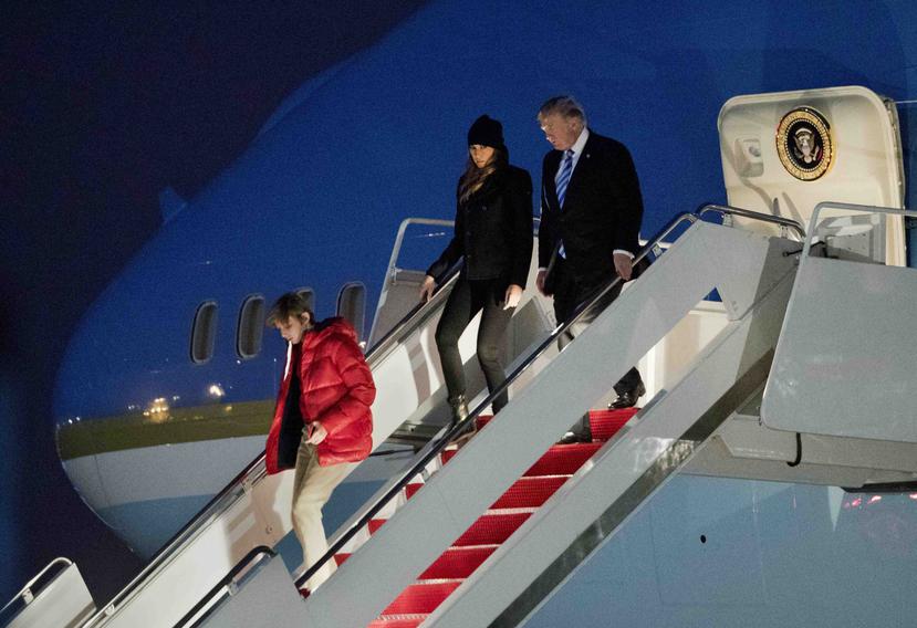 Presidente Donald Trump, primera dama Melania Trump y su hijo Barron Trump desembarcan del avión presidencial. (AP)