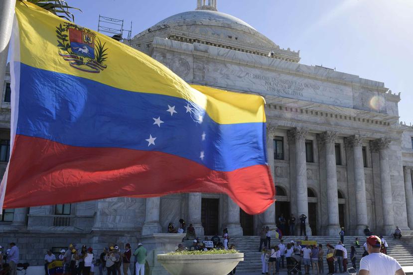 La bandera de Venezuela ondea frente al Capitolio de Puerto Rico durante la manifestación.