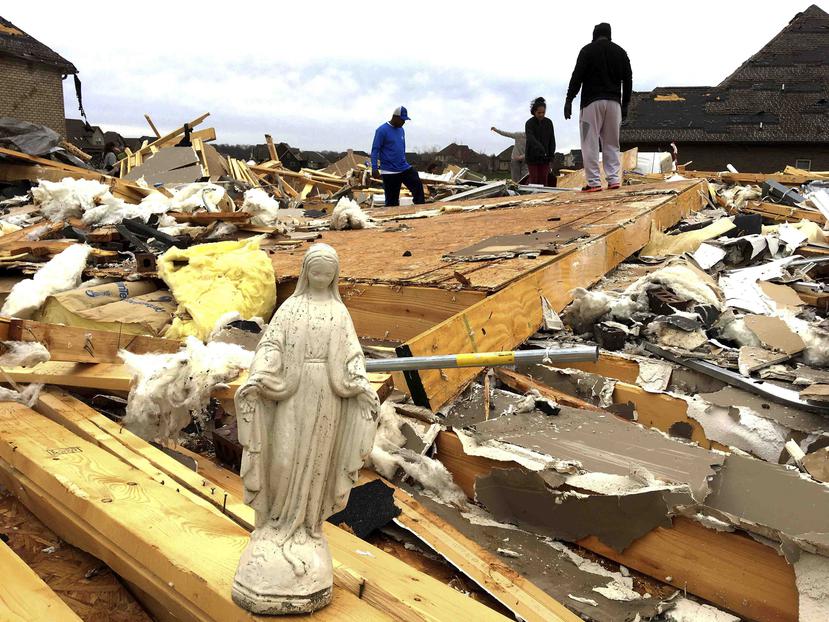 Una estatua de María figura entre diversos objetos que voluntarios rescataron de los escombros. (AP)