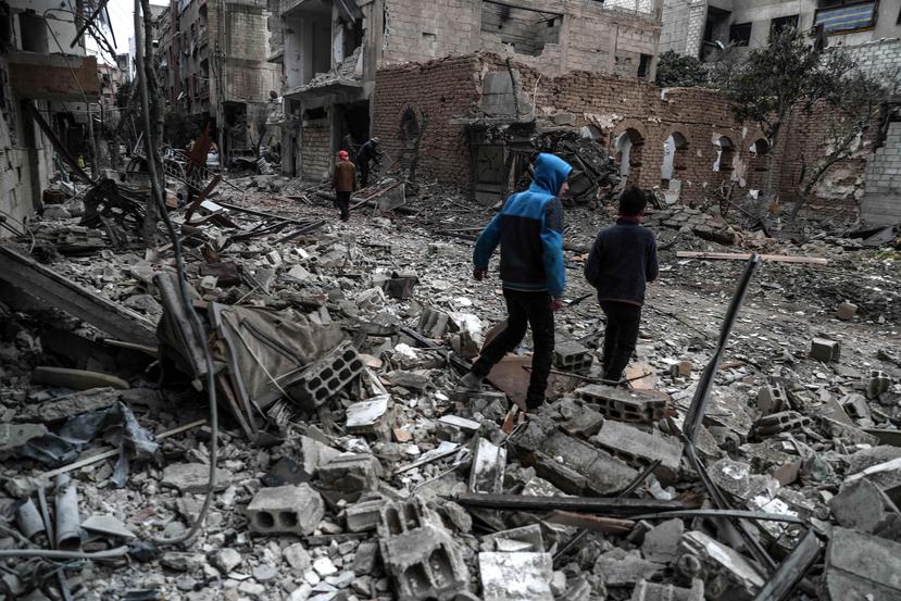 Vecinos inspeccionan los edificios en ruinas después de varios bombardeos el día anterior, en Duma, feudo rebelde de Guta Oriental, Siria (EFE).