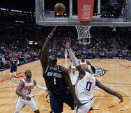 El alero de los Pelicans de Nueva Orleans Zion Williamson avanza y salta hacia la canasta para encestar frente al alero de los Suns de Phoenix Torrey Craig.