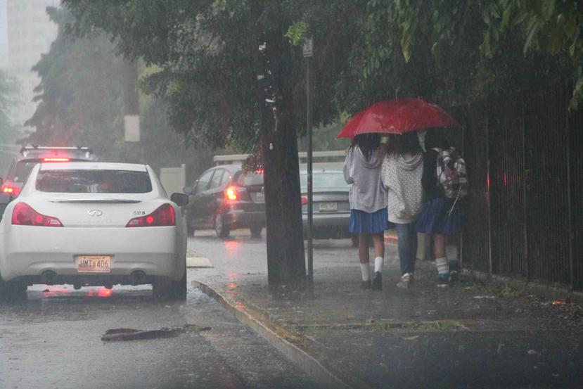 Unas estudiantes se escudan de la lluvia con una sombrilla. (GFR Media)