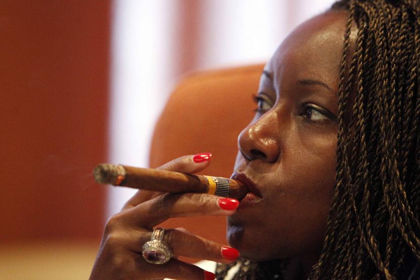 Una mujer posa para una foto fumándose un tabaco durante la inauguración del Festival del Habano en La Habana, Cuba.