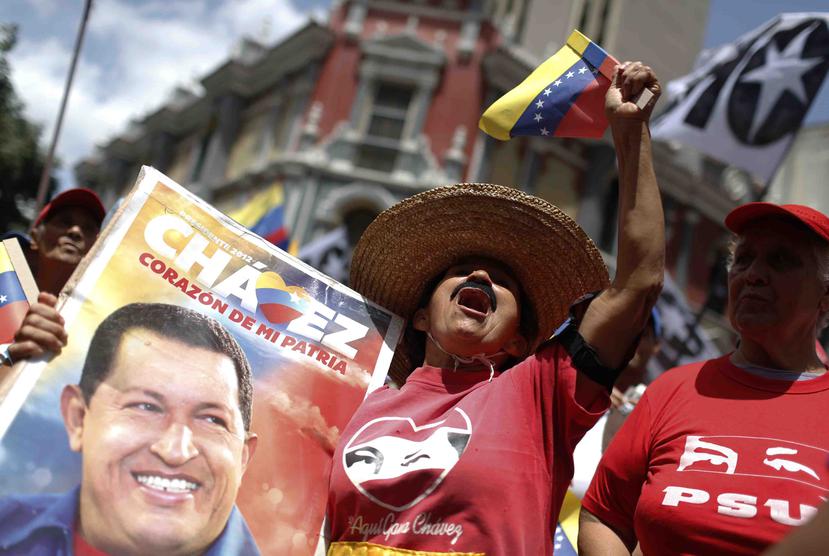 Una seguidora del gobierno sostiene una imagen del fallecido presidente venezolano Hugo Chávez. (AP/Leonardo Fernández)
