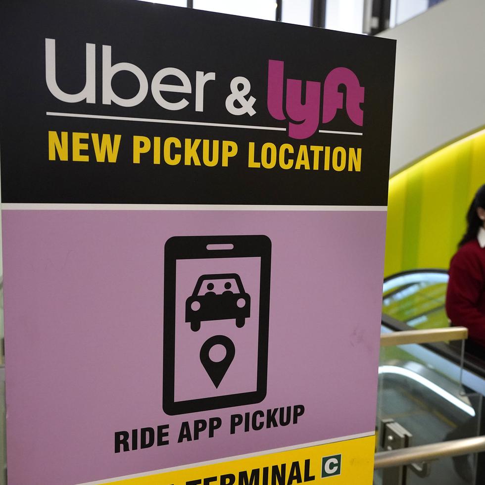 Una persona pasa por un letrero que ofrece a las personas dónde ser recogidas por un vehículo de Uber o Lyft en el Aeropuerto Internacional Logan en Boston.