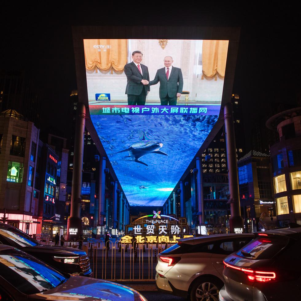 Imagen del encuentro de los presidentes chino, Xi Jinping, y ruso, Vladimir Putin, en una pantalla gigante en Pekín. (EFE/EPA/WU HAO)