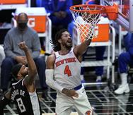 El base de los Knicks de Nueva York Derrick Rose anota superando al alero de los Clippers de Los Ángeles Marcus Morris en el encuentro del domingo 9 de mayo del 2021. (AP Photo/Marcio Jose Sanchez)
