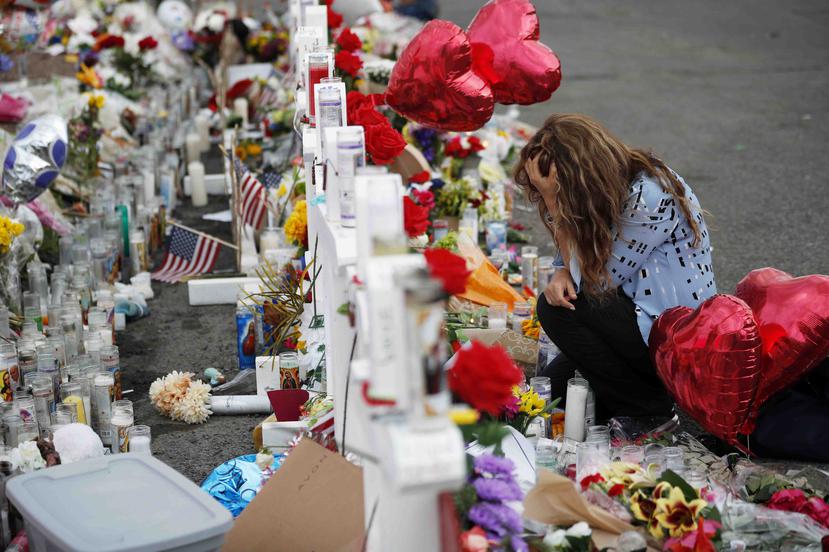 Gloria Garcés se arrodilla frente a un altar improvisado en el lugar donde ocurrió una masacre en un complejo comercial en El Paso, Texas, el martes 6 de agosto de 2019. (AP)