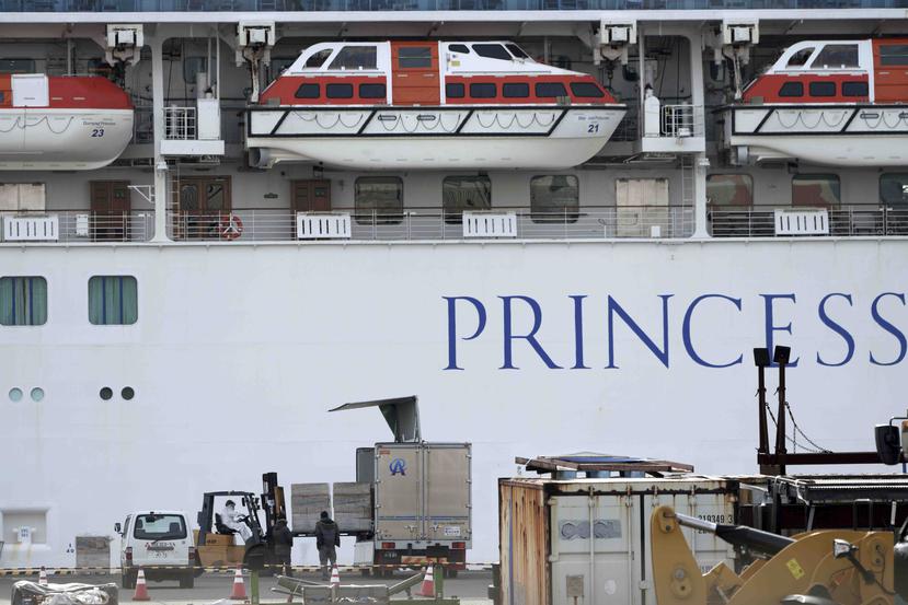Funcionarios descargan suministros para el crucero Diamond Princess anclado en el puerto de Yokohama en Yokohama, cerca de Tokio, el viernes 7 de febrero de 2020. (AP/Eugene Hoshiko)