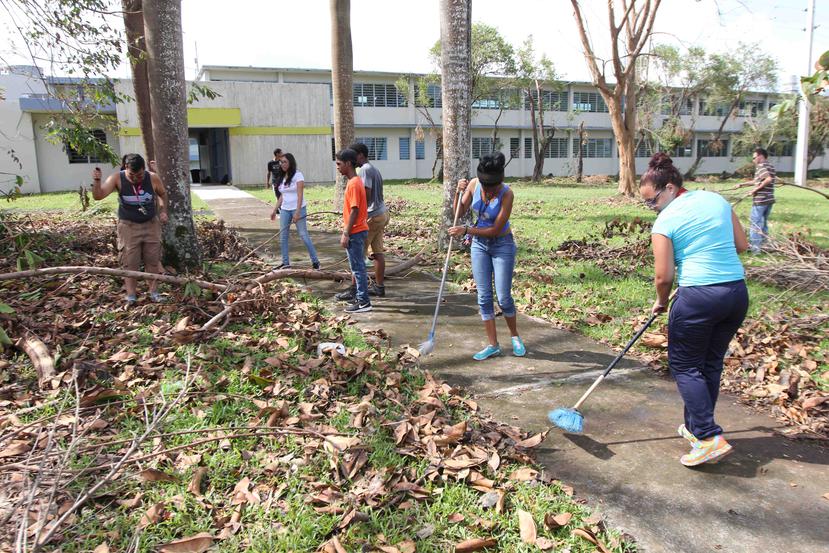 Estudiantes de la escuela Trina Padilla de Sanz en San Juan ayudan en la limpieza del plantel que cocina comida para cientos de refugiados pese a que el gobierno no les ha llevado diésel para su genereador de electricidad.