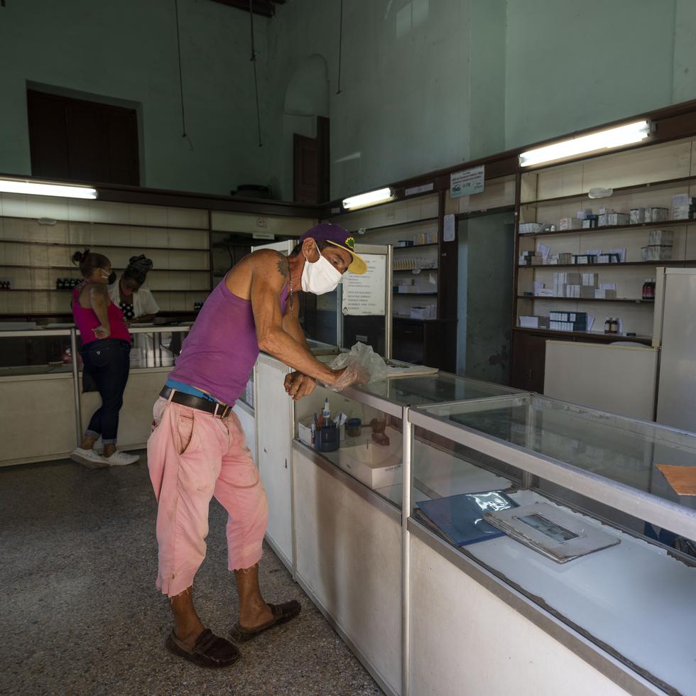 Un hombre espera ser atendido en una farmacia en medio de la pandemia de COVID-19 en La Habana Vieja, Cuba.